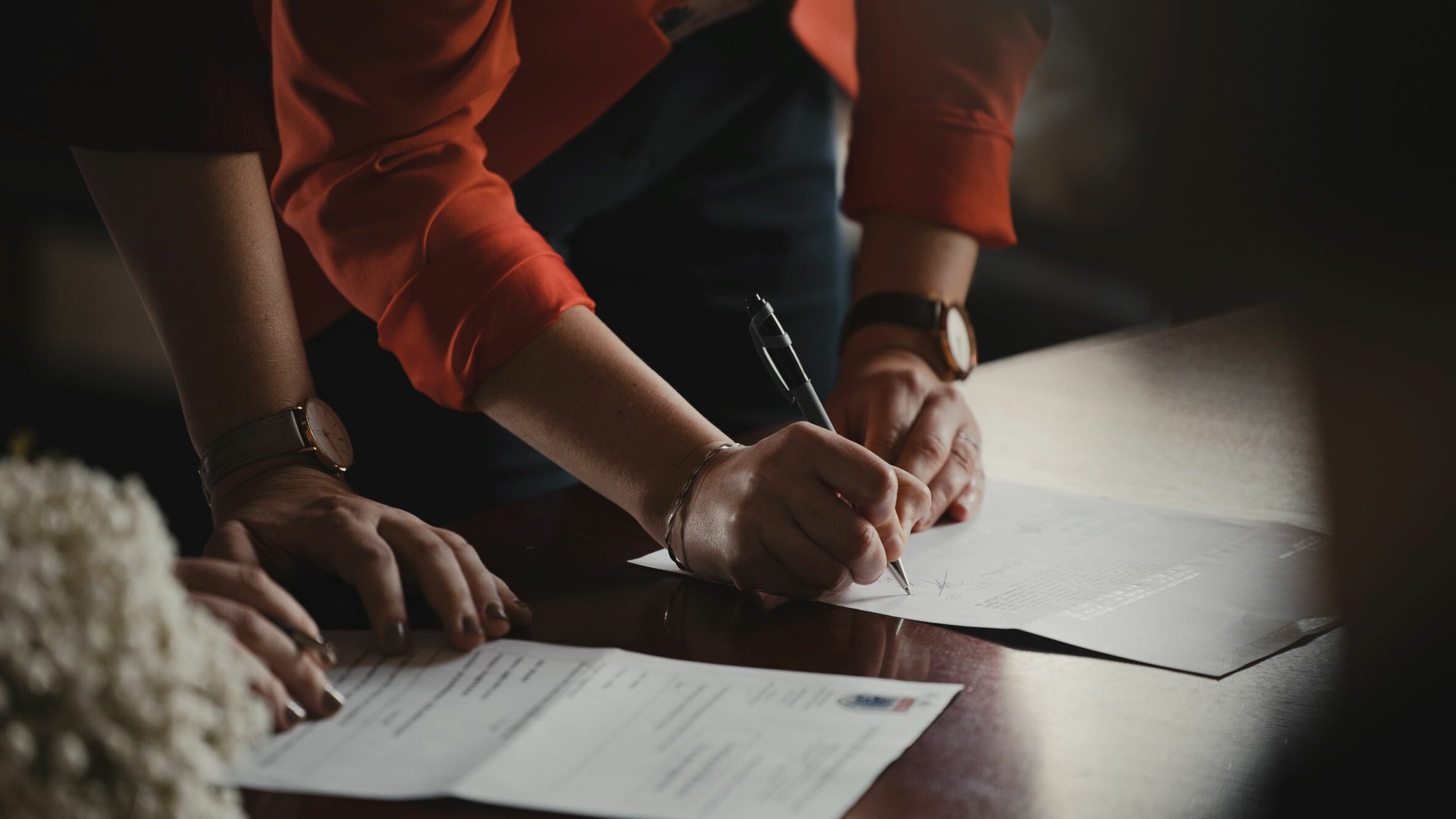 People signing a document.