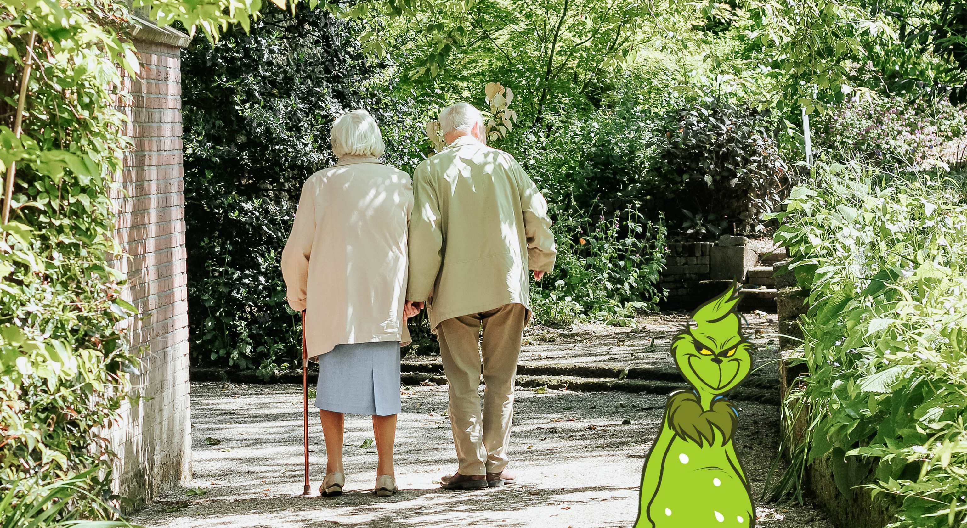 An elderly couple walking down a garden path.