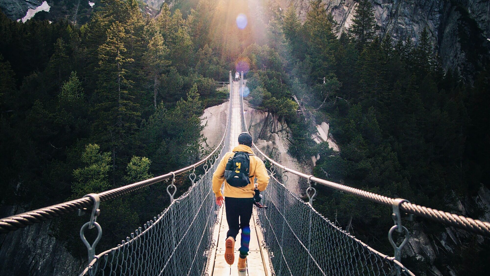 man going across a rope bridge