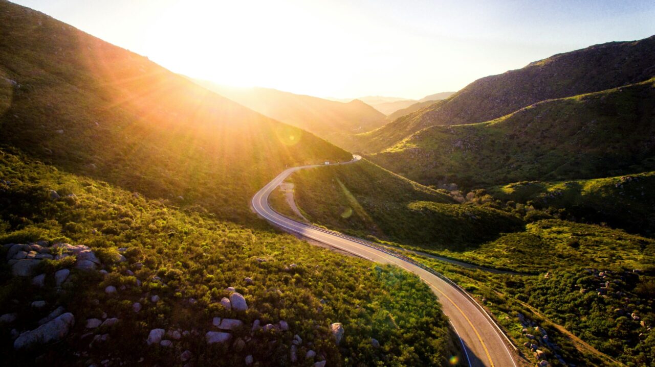 Winding road through mountainside with sunsetting